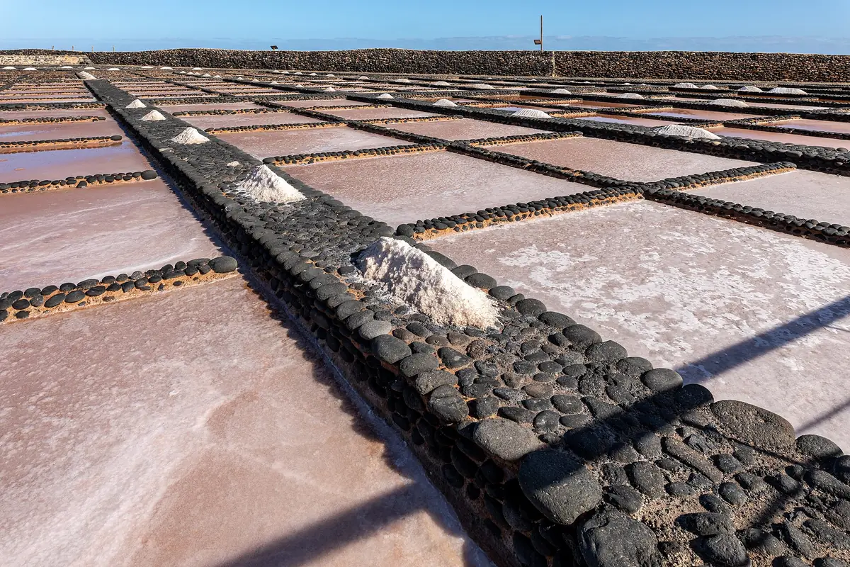 Estanques de cristalización de las Salinas del Carmen, en Antigua, con montones de sal sobre los muros de piedra