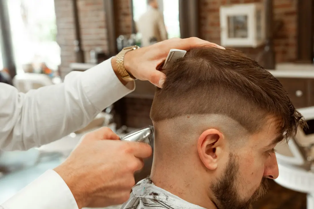 Barbero perfilando un degradado con la máquina
