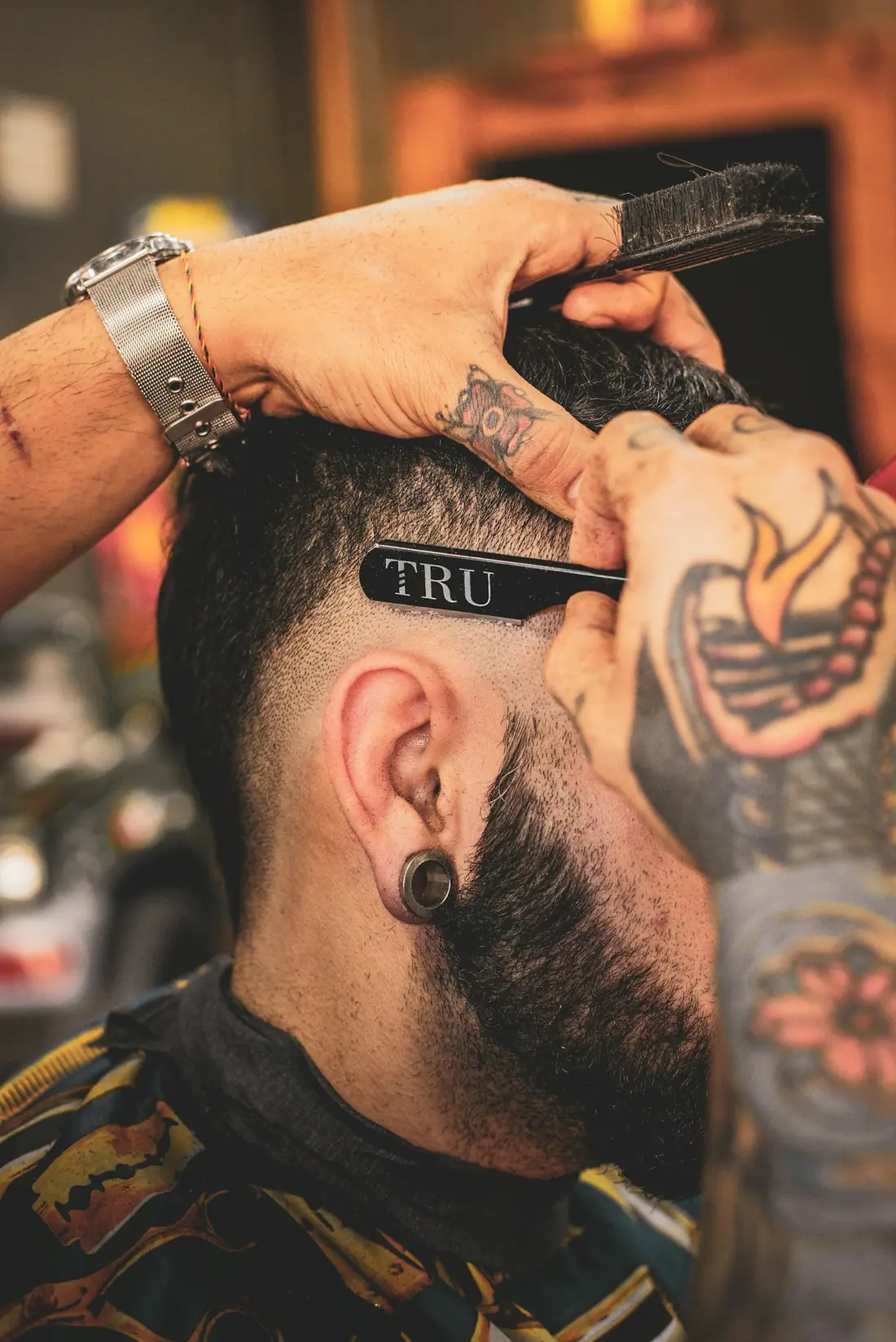 Barbero repasando la nuca con una navaja