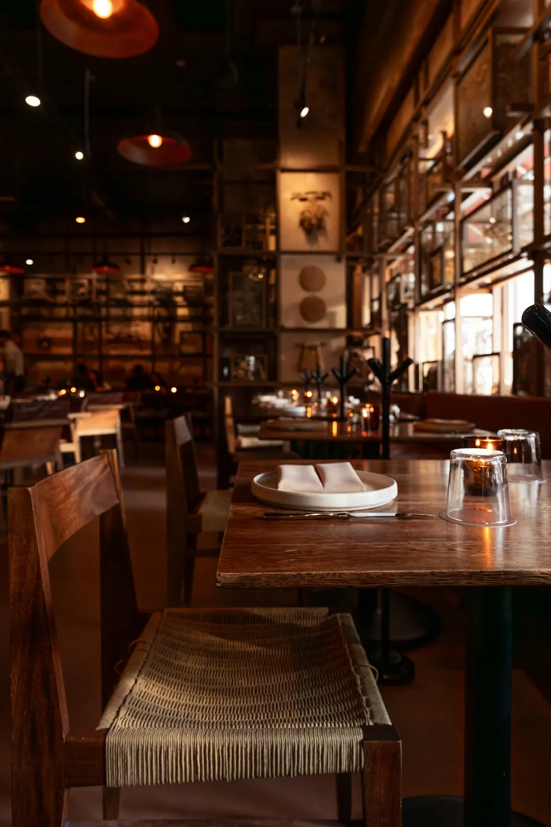 Salón interior con mesas de madera y luz cálida