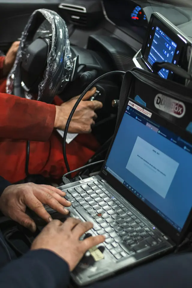Mecánico conectando un portátil de diagnosis al coche